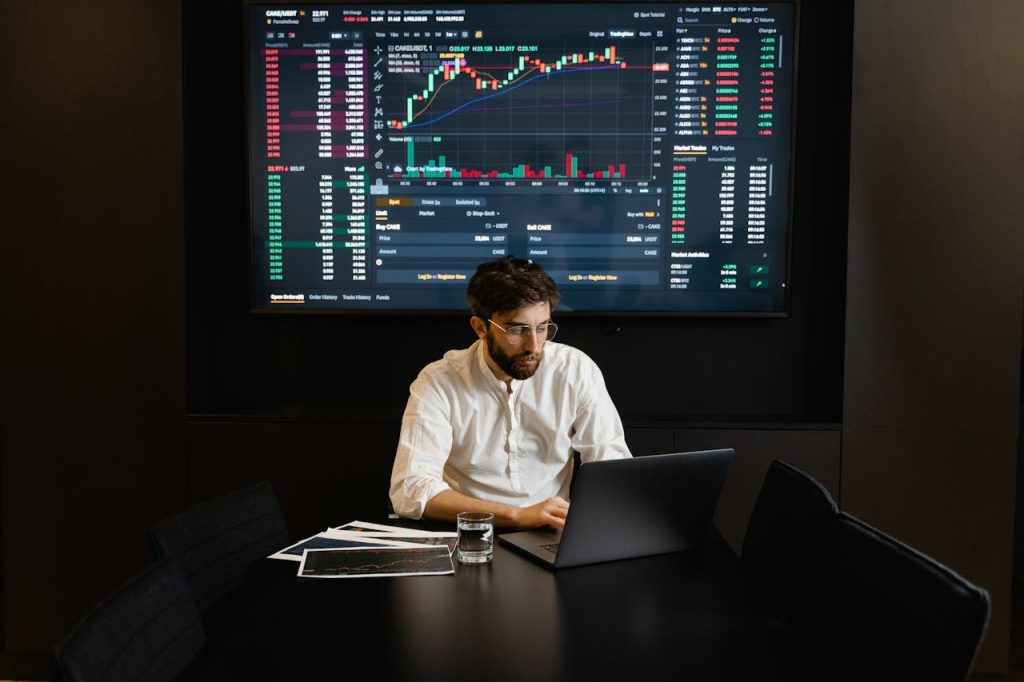 focused businessman analyzing stock market data on laptop with financial graphs displayed on screen 币安app